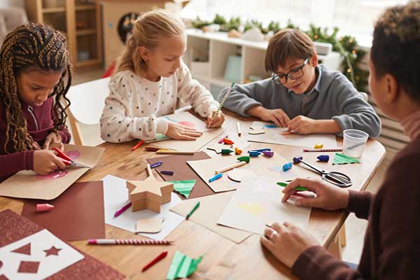 Diverse kids doing holiday projects at a table