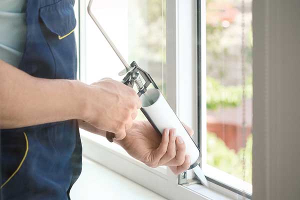 Man caulking window sill