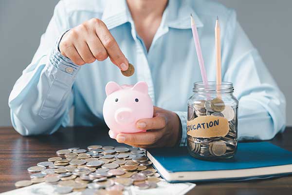Blue shirt with hands saving money in pink piggy bank