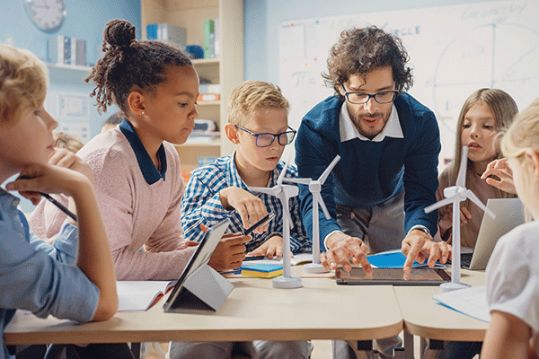 Teacher showing windmills to students in classroom