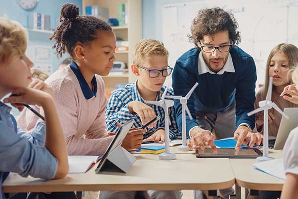 Teacher with students looking at wind turbine examples