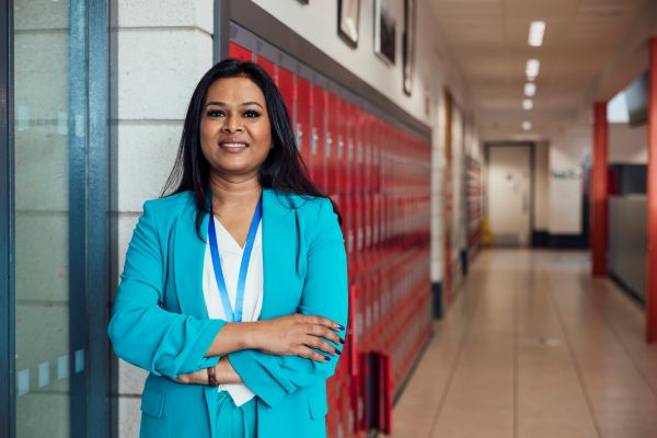 Female teacher standing in school hallway.