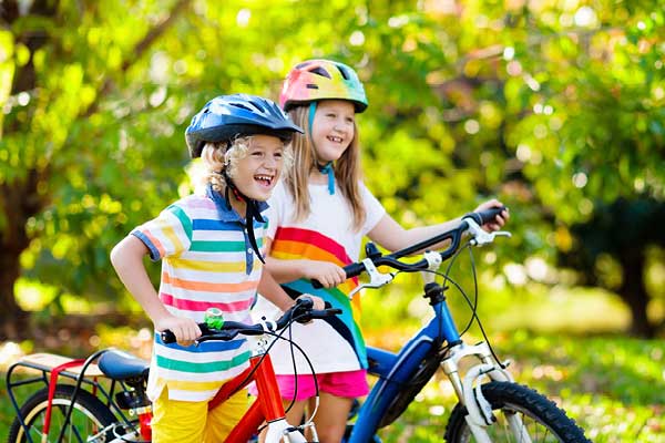 Boy and girl with helmets and bicycles