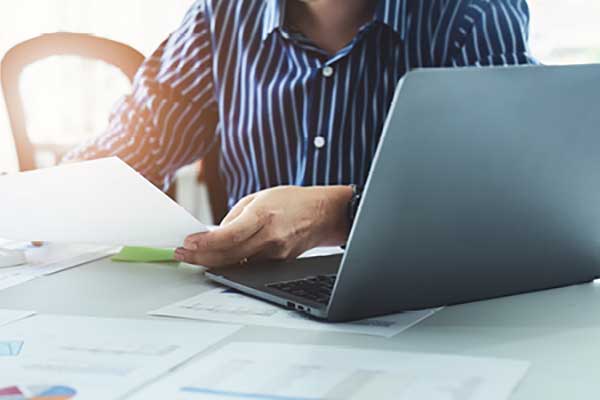 Person in front of laptop developing a budget