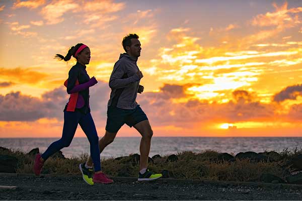 Couple running together at sunset