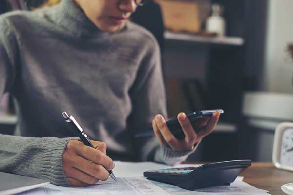 Asian woman with calculator doing finances