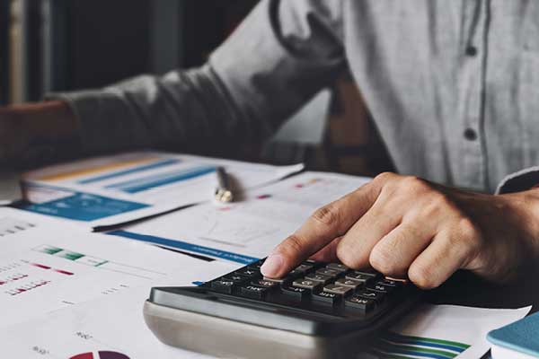 Man doing taxes with calculator