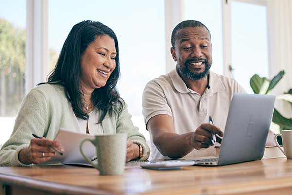 Agent and client looking over retirement plan with laptop