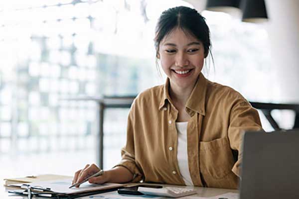 Asian American educator with laptop