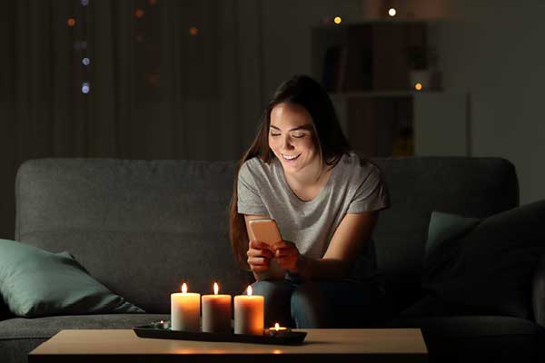 Hispanic woman in front of candles on her sofa