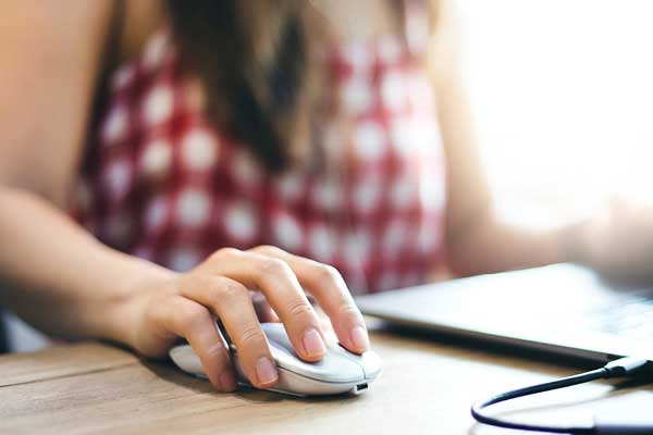 Hand on mouse working on laptop