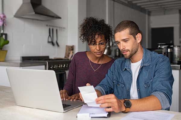 Diverse couple going over retirement savings in front of laptop