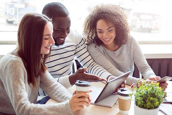 Diverse students around a laptop