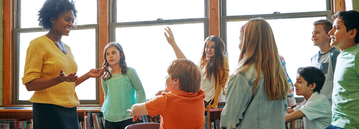 Teacher in classroom with school students