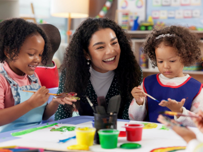 Young female educator at table with two students.