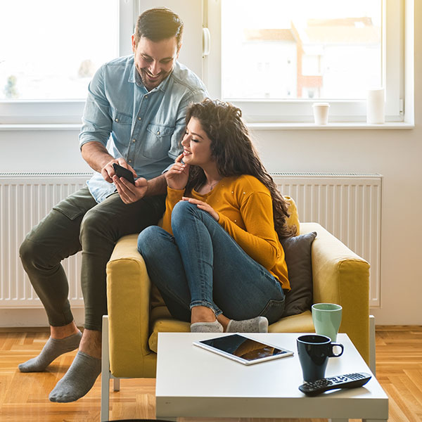 Happy couple looking at message on mobile