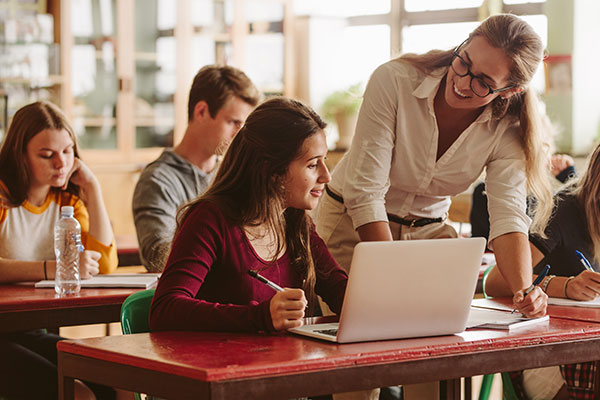 Teacher helping student in classroom
