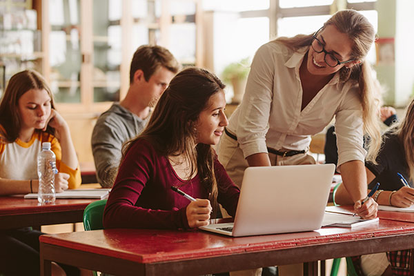 Teacher helping student in classroom