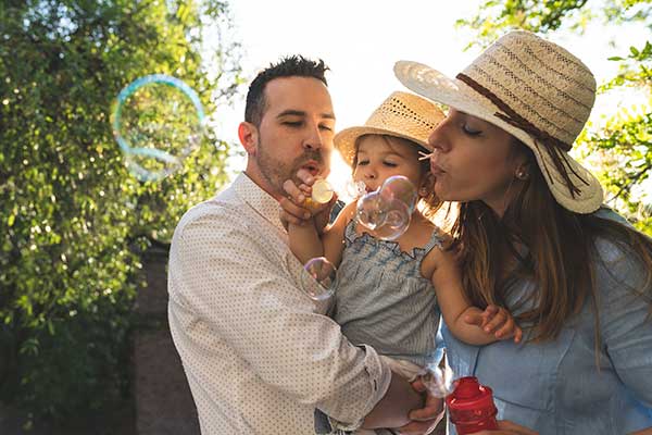 Hispanci family with baby blowing bubbles