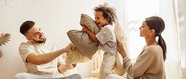 Hispanic family having a pillow fight