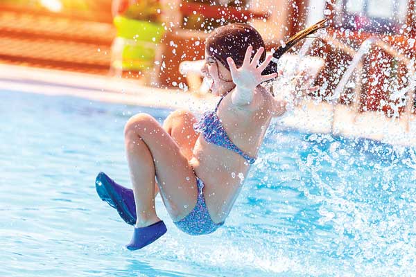 Girl jumping into a swimming pool