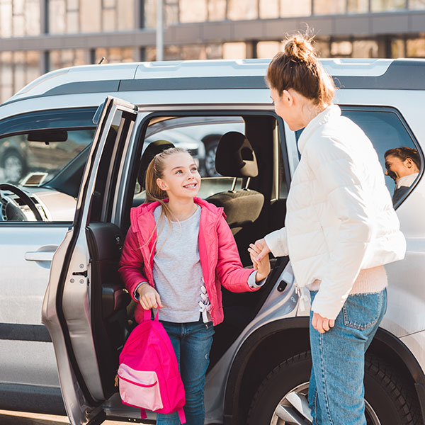 Mother helping daughter out of car