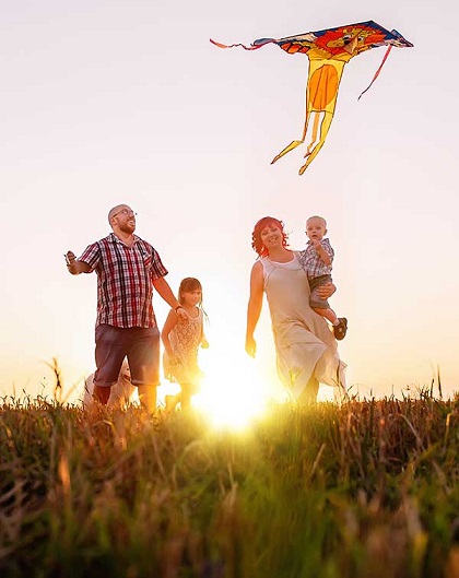 Family outside playing with a kite.